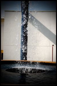 Water splashing on fountain against building