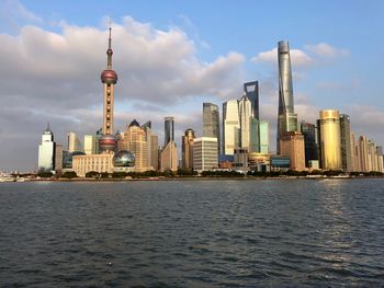 Modern buildings in city against cloudy sky