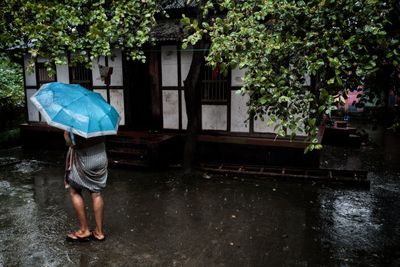 Full length rear view of man walking in rainy season