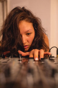 Close-up of fashionable young woman playing music at home