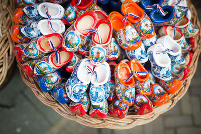 High angle view of colorful clogs shoes in wicker basket for sale at street market