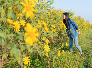 Smiling woman standing by flowering plants