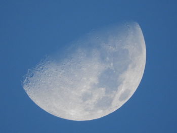 Low angle view of moon against clear blue sky