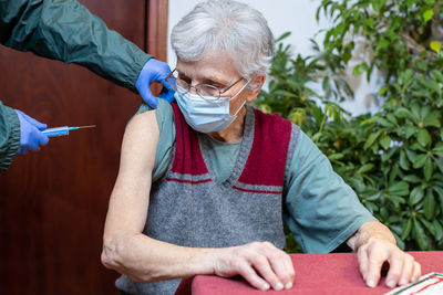 Senior woman receiving the vaccine in nursing home