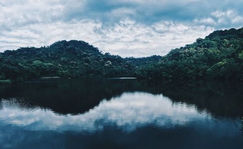 Scenic view of lake by trees against sky