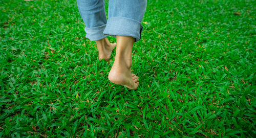 Low section of woman standing on grassy field