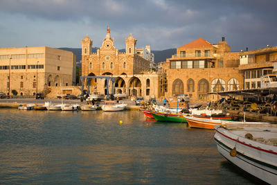 Boats moored at canal against buildings in city