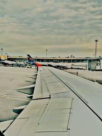 Airplane on airport runway against sky