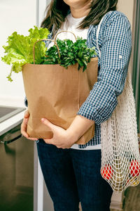 Midsection of woman holding vegetables