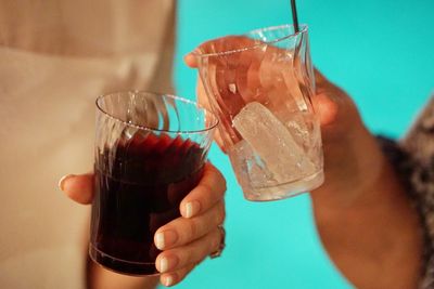 Cropped hands of women toasting drinking glasses