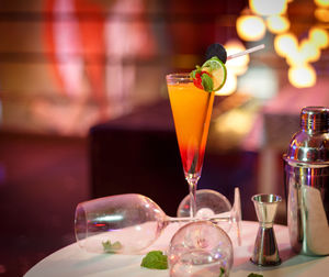 Cocktail with wineglasses on table in illuminated restaurant
