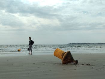 Man standing at beach against sky