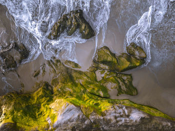 High angle view of stream flowing through rocks