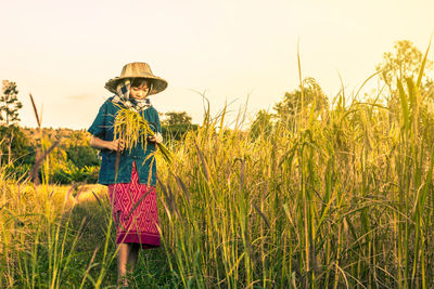 Portrait of happy girl standing on field against clear sky