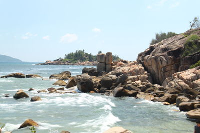 Rocks on beach against sky