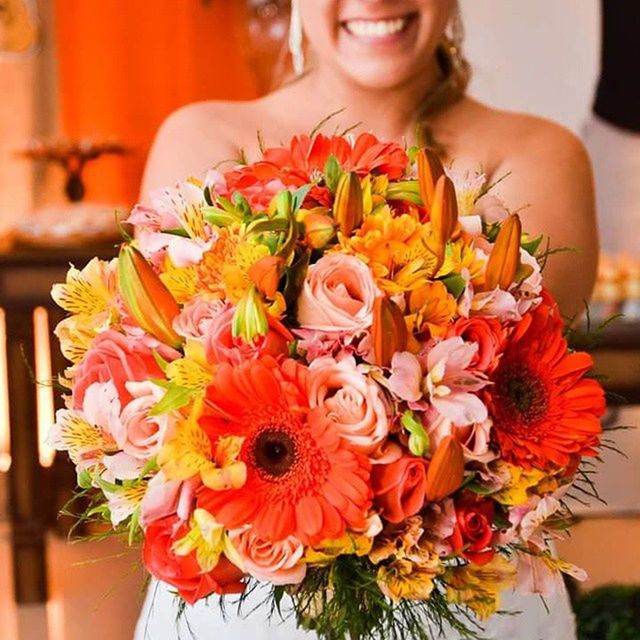 flower, freshness, indoors, lifestyles, person, focus on foreground, holding, front view, leisure activity, fragility, bouquet, young women, casual clothing, young adult, petal, looking at camera, close-up, smiling