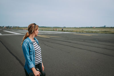 Woman standing on road against sky