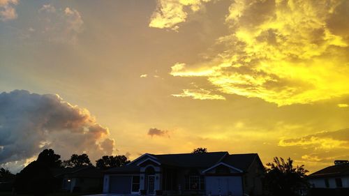 Low angle view of houses against sky at sunset