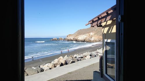 Scenic view of beach against clear blue sky