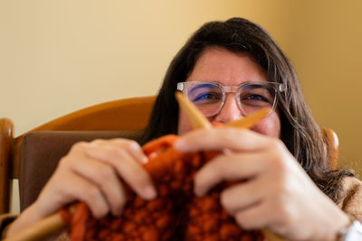 Close-up of woman knitting wool at home