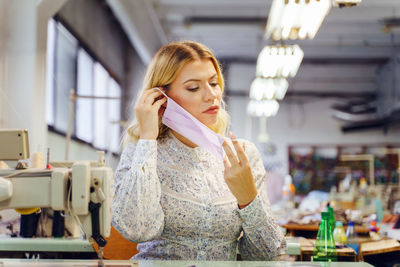 Woman wearing mask while working in factory