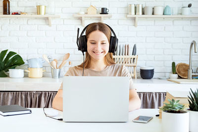 Mid adult woman using mobile phone at home