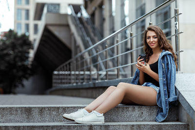 Young woman sitting on staircase