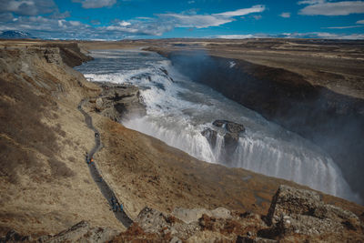 Scenic view of waterfall against sky