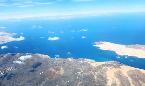 Aerial view of sea and mountains against sky