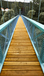 Central perspective of an iron bridge for pedestrians with a wooden floor