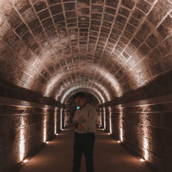 Man standing in illuminated tunnel