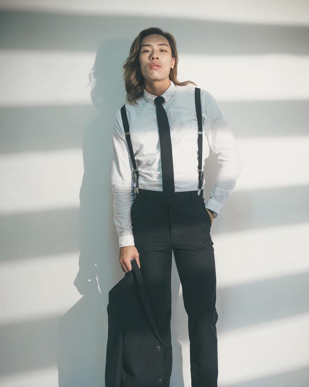 PORTRAIT OF WOMAN STANDING AGAINST WALL