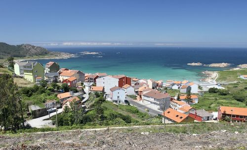 High angle view of townscape by sea against sky