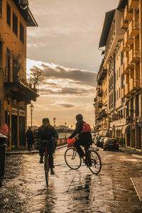 People riding bicycle on street in city