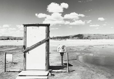 Lifeguard hut on field against sky during winter