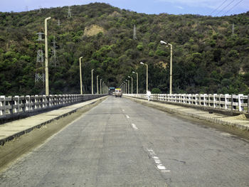 Road by bridge against sky