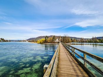 View of bridge over calm river against sky