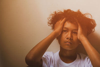 Portrait of teenage girl against wall at home