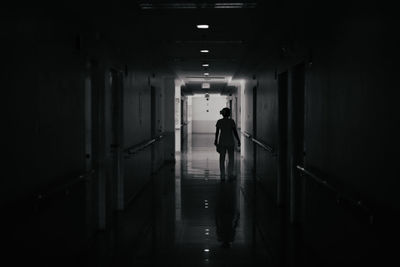 Rear view of woman walking in corridor of building