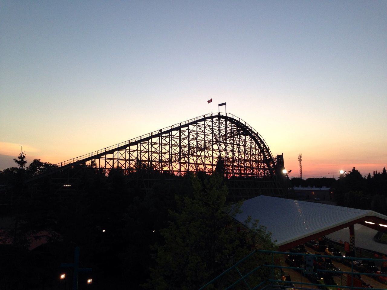 sunset, built structure, architecture, clear sky, copy space, silhouette, building exterior, bridge - man made structure, connection, bird, orange color, dusk, ferris wheel, sky, low angle view, city, amusement park, outdoors, no people, engineering