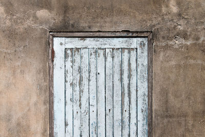 Old wooden plank door with concrete wall