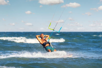 Man surfing in sea against sky