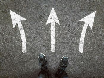 Low section of man standing on road