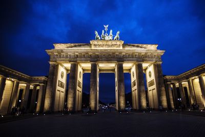 Low angle view of illuminated building against clear sky at night