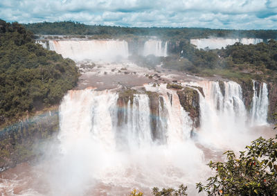 Scenic view of waterfall against sky