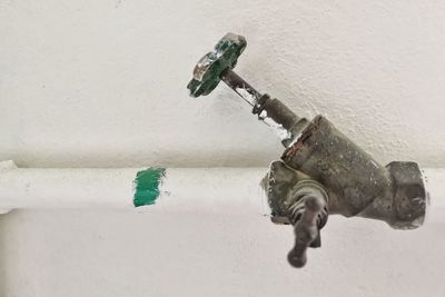 Close-up of faucet on white wall