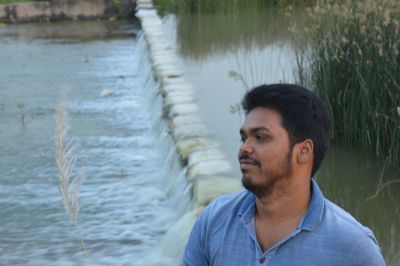 Portrait of young man looking away in lake