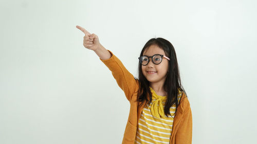 Portrait of smiling young woman against white background