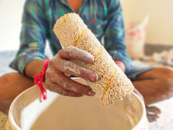 A painter holds a paint roller. painting the wall with a paint roller.