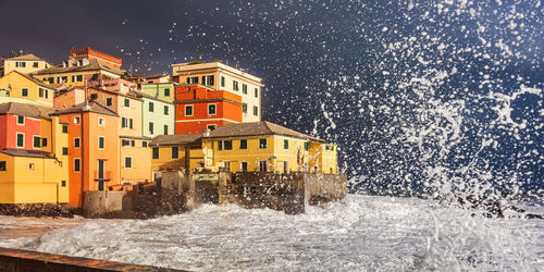 Houses by sea in city during winter